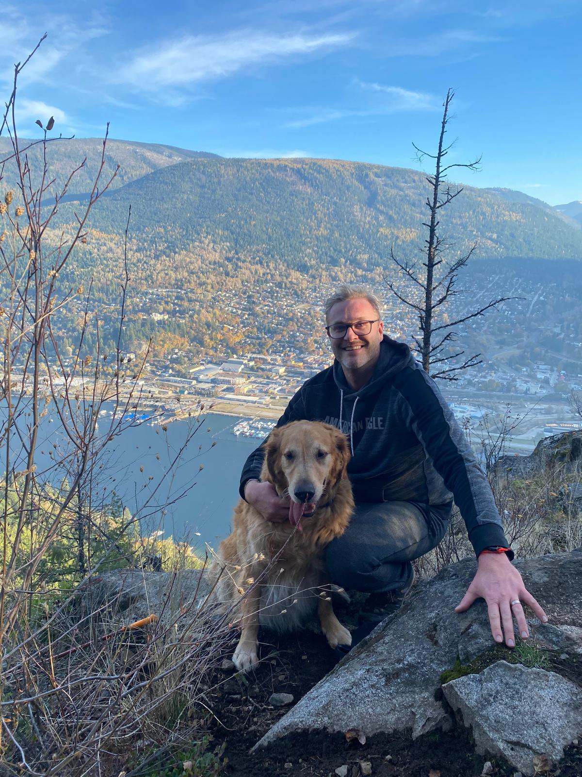 Geoff, founder of K9-8, with his golden retriever Benji overlooking the Kootenay Mountains, BC